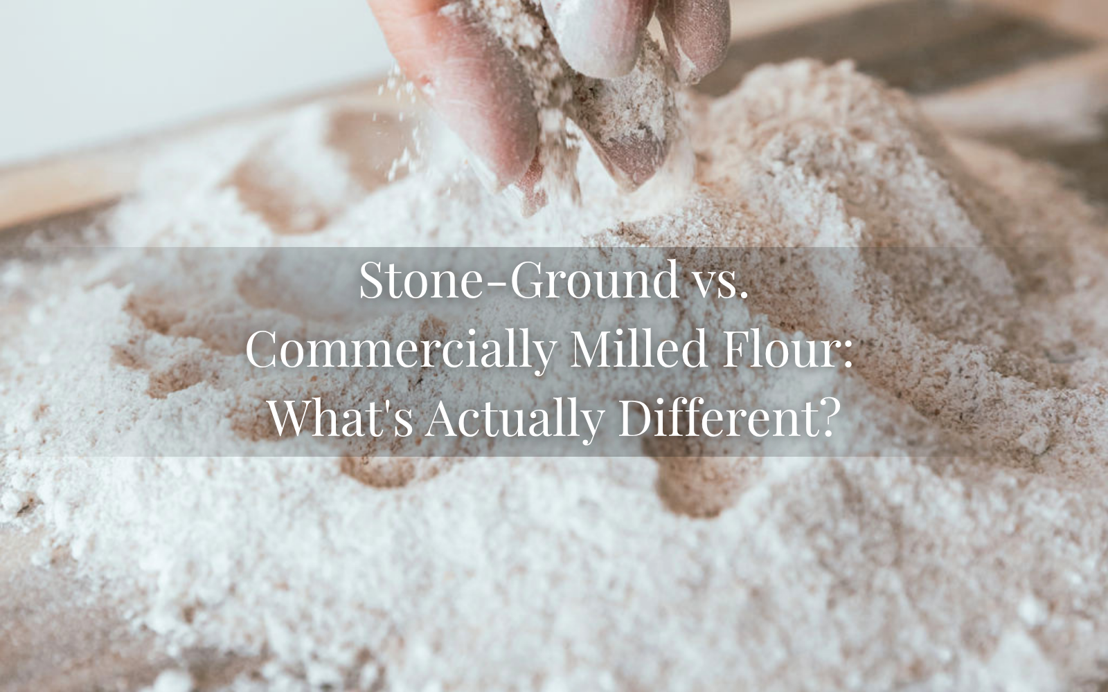 Close-up of hands sifting freshly milled flour over a wooden surface, illustrating the difference between stone-ground flour and commercially milled flour.